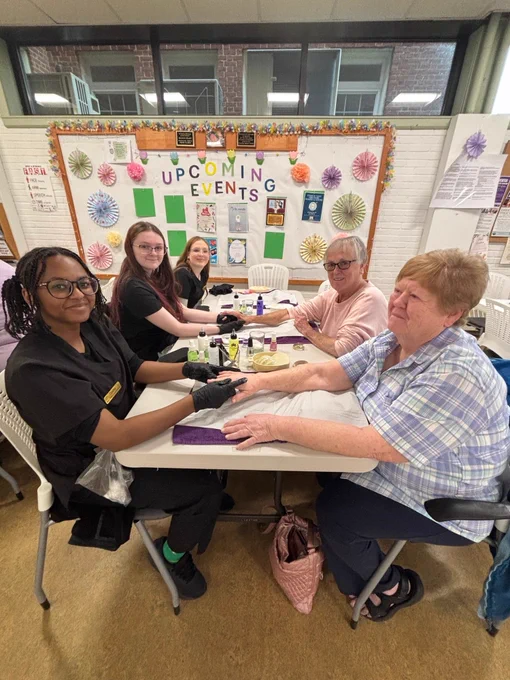 Pictured are cosmetology students giving older adults manicures