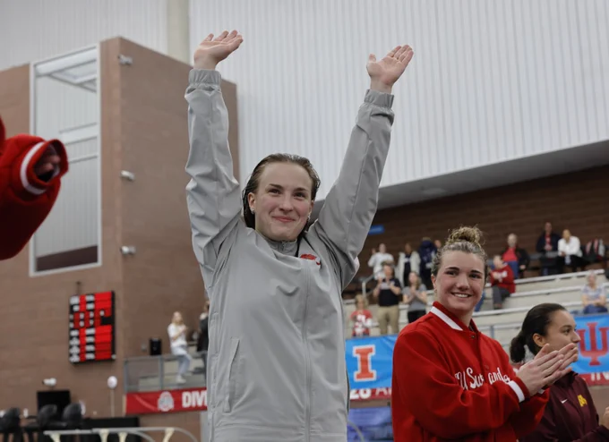 Lena holding her hands up saluting the crowd at the Big Ten Championship