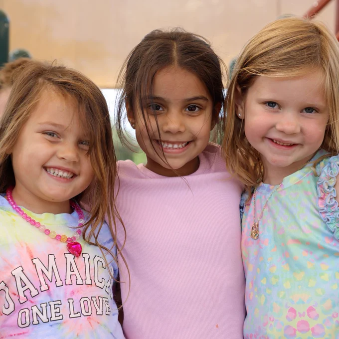 Three children smiling together for a group photo