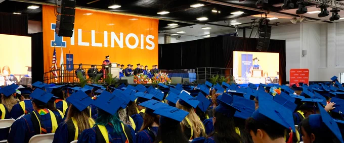 Interim Dean Emily Knox speaks on stage in front of a sea of iSchool graduates. 