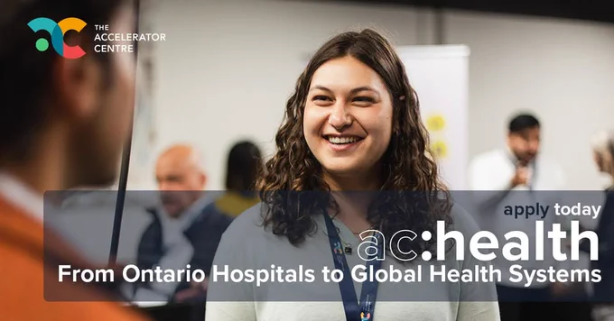A person smiling while engaging in conversation at a conference event with The text overlay that says "apply today ac: health - From Ontario Hospitals to Global Health Systems” with the Accelerator Centre logo displayed in the top left corner. 