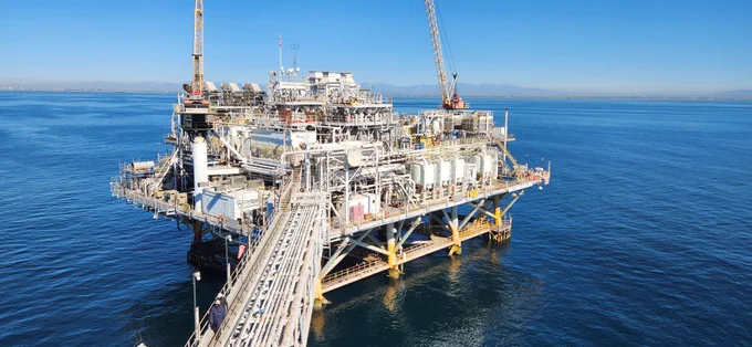 An offshore oil and gas platform sits in the blue ocean. Photo Credit: Abigail Ryder, BOEM 