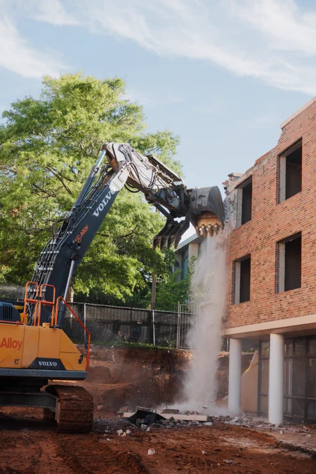 A photo of demolition beginning via excavator on McBryde residence hall at the University of South Carolina