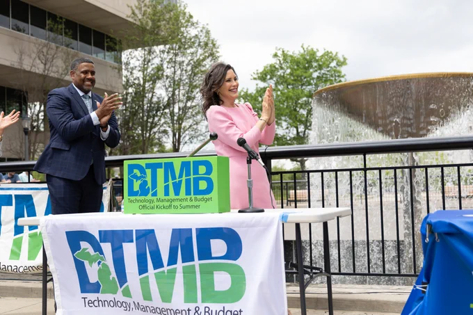DTMB Acting Director Kyle Guerrant and Gov. Whitmer clapping after the turning on of the Brian J. Whiston Memorial Fountain.