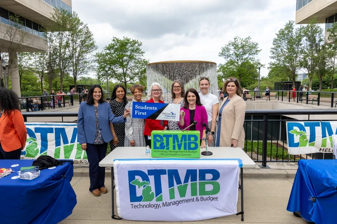 State of Michigan employees posing in front of the Brian J. Whiston Memorial Fountain.