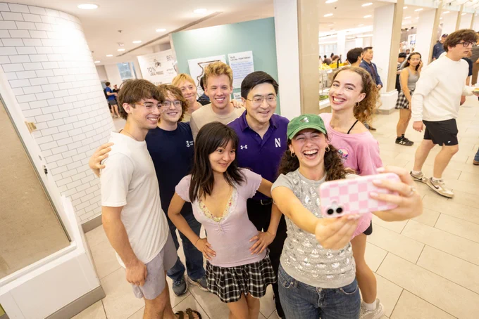 President-elect Mung Chiang greets students at Allison Dining Commons and poses with them for a selfie.