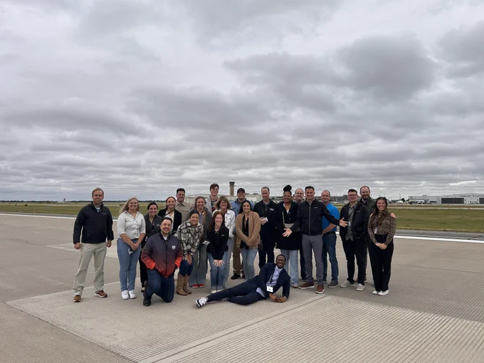 Picture of a group of people standing on the ICT airfield.