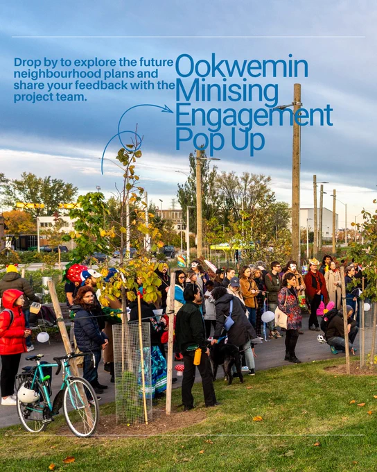 A group of people gather at an outdoor event near Ookwemin for a community engagement pop-up. Bicycles are parked nearby, and several young trees are planted along the path. A banner invites attendees to explore future neighborhood plans and provide feedback.