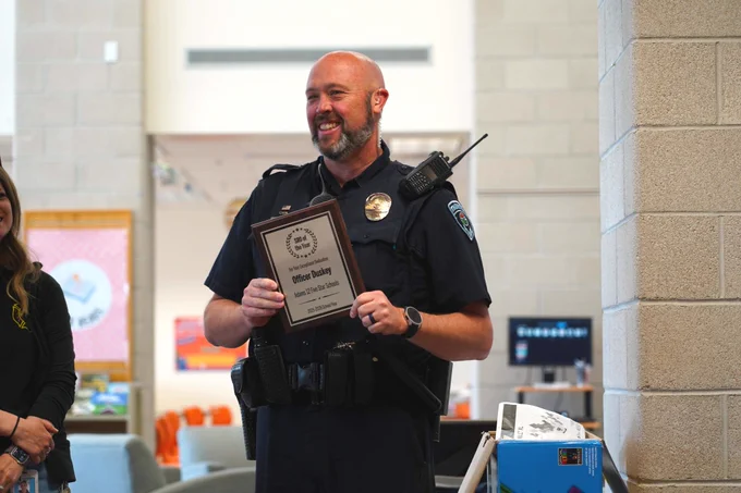 Officer Duskey smiling while holding his award
