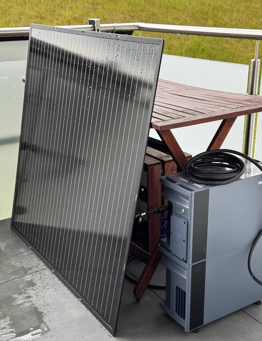 Zu sehen sind ein Schwaiger PV-Modul angelehnt an einen Holztisch unter dem ein Growatt Wechselrichter und ein Indevolt Speicher stehen. Das PV-Modul ist an einen MPPT-Eingang des Speichers angeschlossen. Der Wechselrichter ist verbunden mit dem Bypass-Eingang des Indevolt Speichers.