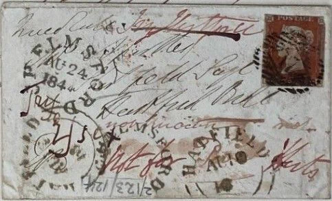 Envelope with an address, some red stamps and notes regarding misdirection 