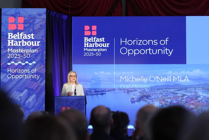 Image of one person, First Minister Michelle O’Neill, behind lectern, addressing audience at launch of Belfast Harbour Masterplan