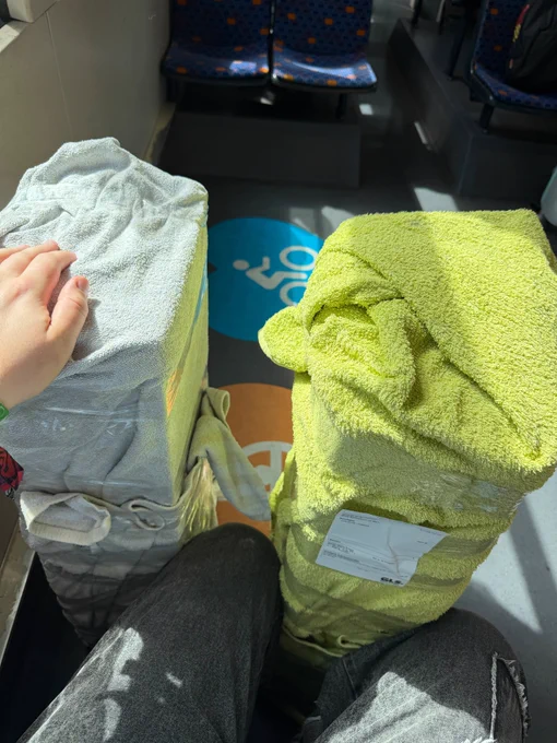 two large boxes wrapped into towels on a train