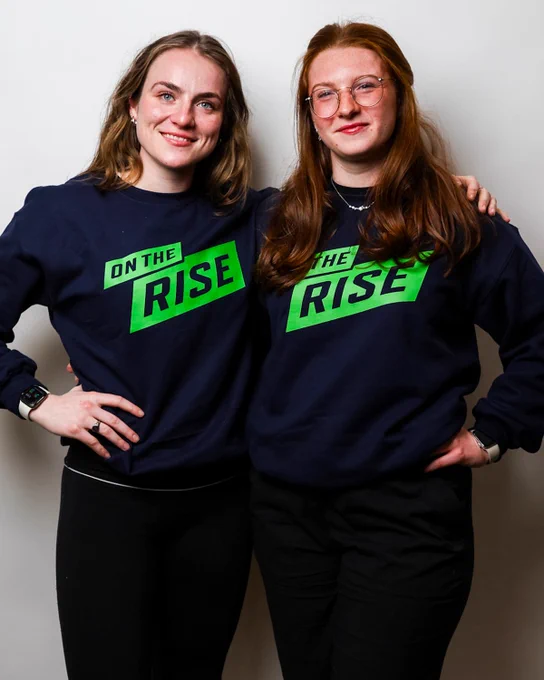 Photo of two women's student-athlete showing off the new OUA On the Rise Sweater 