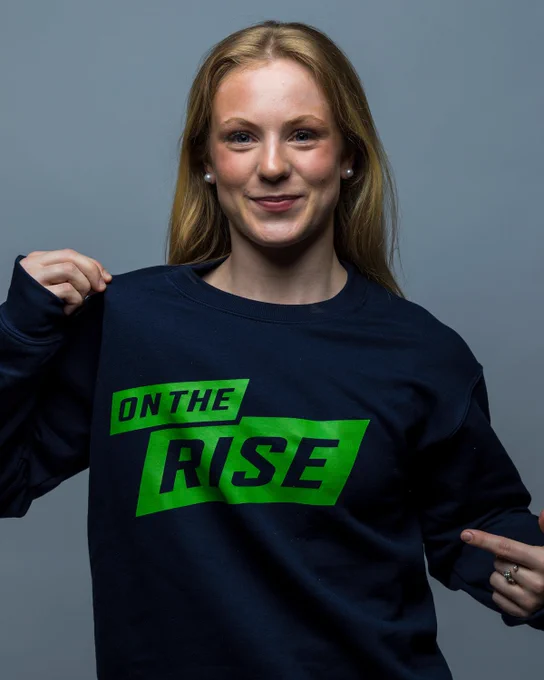Photo of a women's student-athlete showing off the new OUA On the Rise Sweater