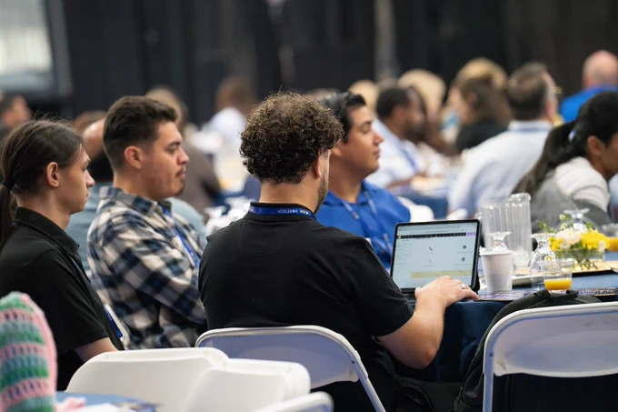 Image of attendees with computer and taking notes during the NextTech Kern event at tables