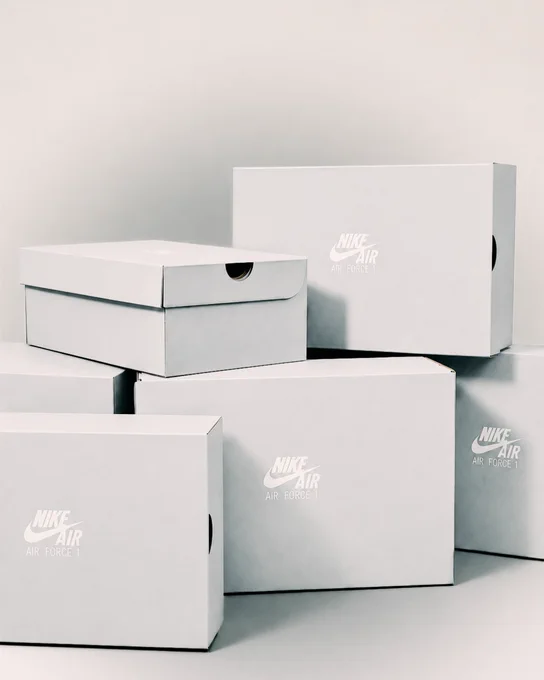 An image of multiple white Nike shoe boxes sitting in a pile together against a white backdrop.