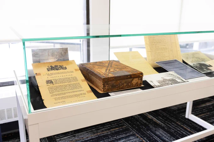 display case with documents and small old wooden box inside