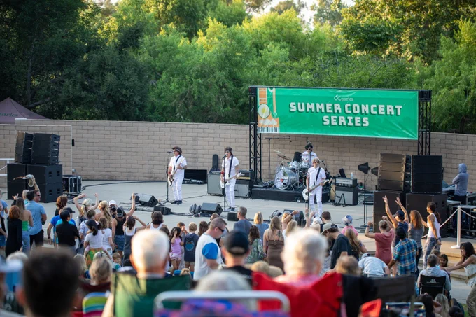 Band poses in front of crowd.

