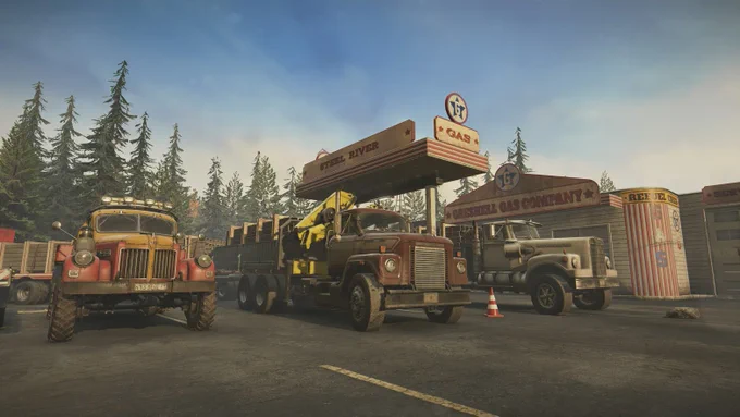 Three vintage trucks parked outside a rustic gas station surrounded by tall pine trees under a clear sky.