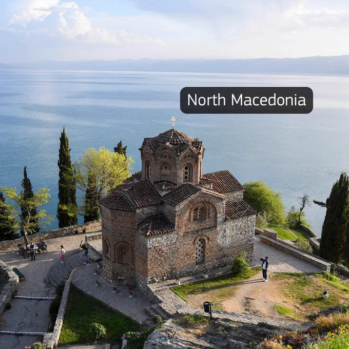 Image of the Church of St. John at Kaneo in North Macedonia overlooking a large lake and surrounding landscape.