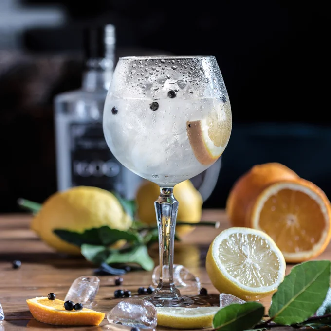Gin in glass on table with oranges and lemons 