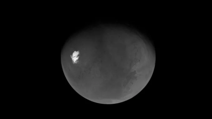 Una vista en escala de grises del globo marciano sobre un fondo negro, que muestra una brillante capa de hielo polar blanca en fuerte contraste con el terreno texturizado y lleno de cr\u00E1teres del planeta. \n