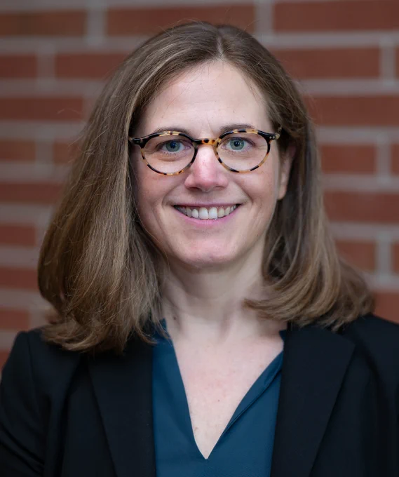 Lisa Linnenbrink-Garcia headshot. Linnenbrink-Garcia wears a blue blouse under a black blazer and tortoise-shell glasses. Linnenbrink-Garcia's hair is ashy blonde and about shoulder length. 