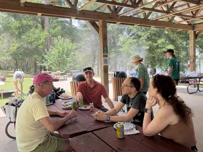 A group of picnic attendees chatting at a table.
