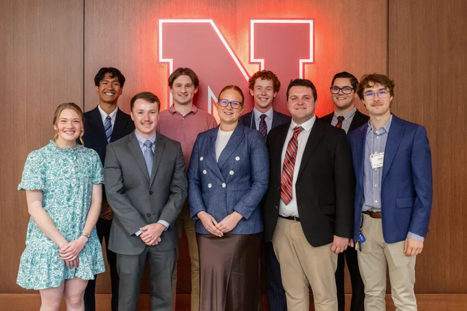 Group of students stand in front of University of Nebraska's "N" logo.