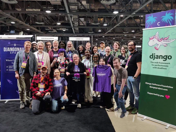 Group photo of Django and Python community members gathered at the Django Software Foundation and Djangonaut Space booth during PyCon US.