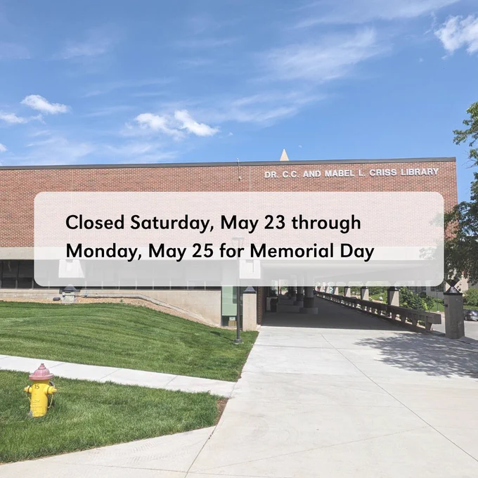 A brick building and an outside walkway. There is a grassy lawn to the left of the building. The text overlay says 'Closed Saturday, May 23 through Monday, May 25 for Memorial Day.'