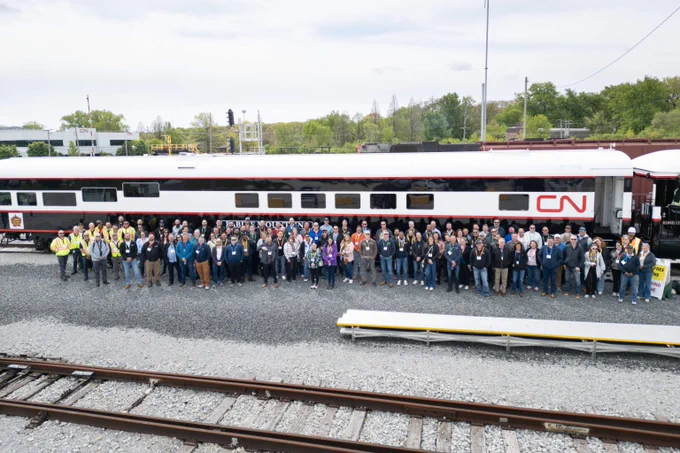 Large group of award recipients stand in front of a CN train car.