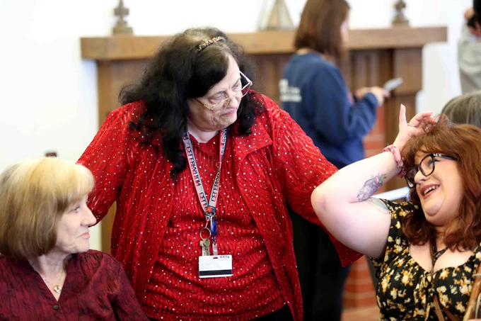Pictured is a photo of UTA Libraries staff member Donna Kelley talking with two people at her retirement party.