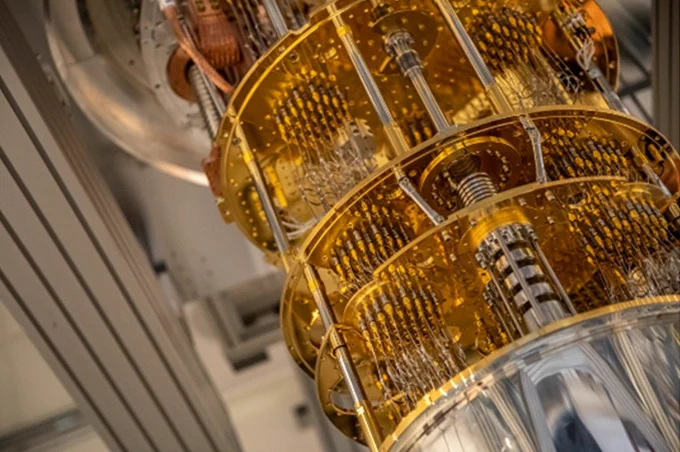A quantum computer, which is made up of several gold disks connected by a column through the middle and gold wires on the outside