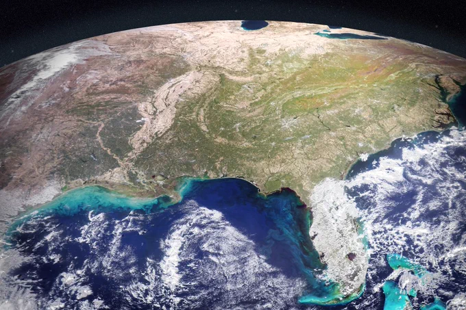 Satellite view of the eastern United States from space during autumn, showing the curve of the Earth, changing leaf colors across the Appalachian Mountains, and vibrant turquoise sediment plumes swirling in the Gulf of America. Credit: NASA