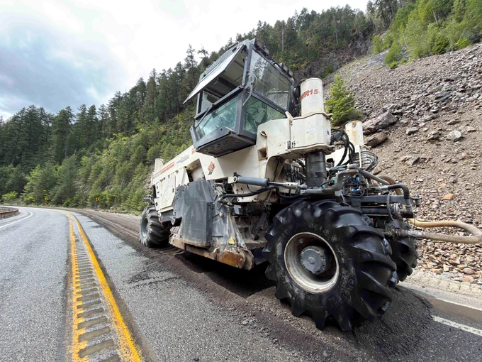 A pulverizer grinds up damaged sections of asphalt to rebuild that roadbed along a rural section of State Route 20.
