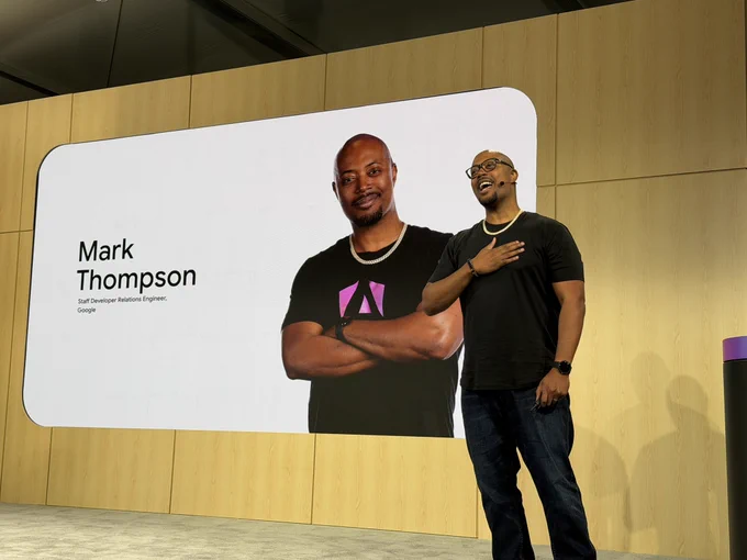 Mark with his speaker slide with his hand on his chest