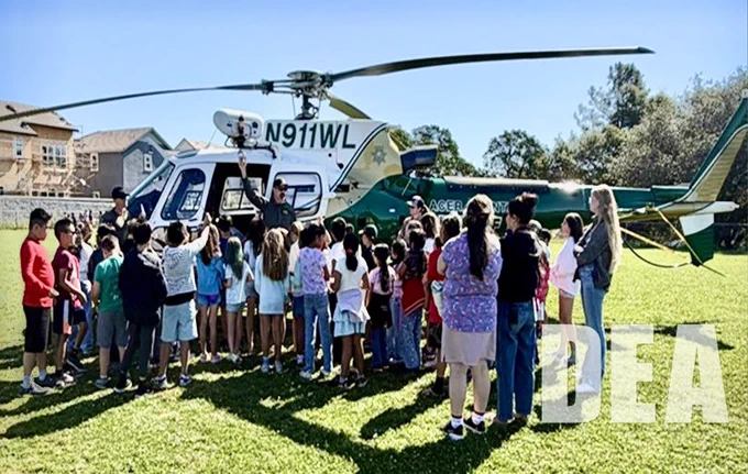 Students gathered around a law enforcement helicopter during outreach event
