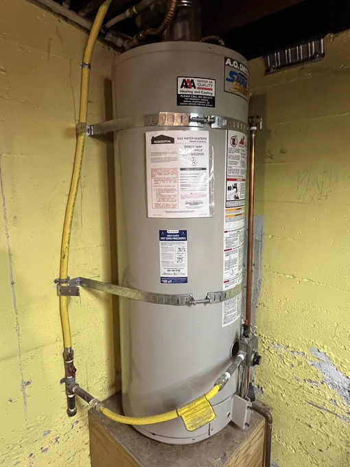 This is a 50-gallon gas water heater that is strapped to nearby basement foundation walls to prevent it from tipping over in an earthquake.