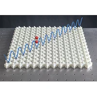 A picture of a two-dimensional phononic crystal overlayed with a schematic of a bound pair state.