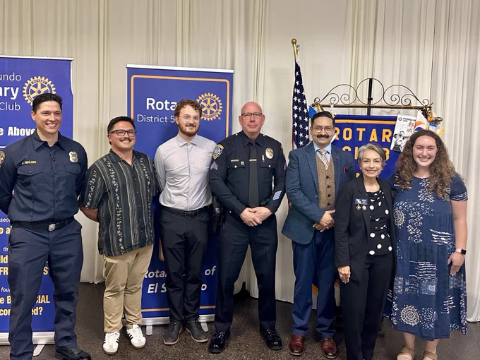 Group photo at a Rotary Club event featuring community members, public safety personnel, and a student participant.