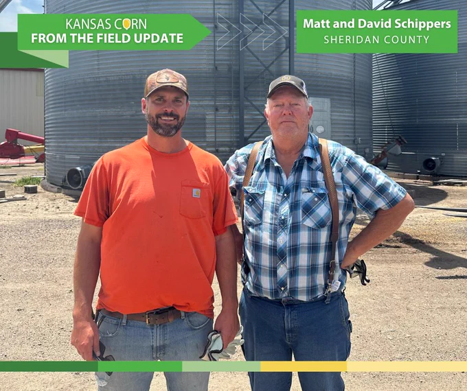 Matt and David Schippers in front of large grain silos on a sunny day in Sheridan County, Kansas.