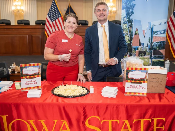 Members of Iowa State's federal relations team standing behind a table with a red Iowa State table cloth. They are holding samples of cheese and ice cream.