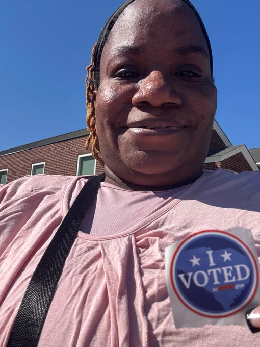Hope- a black woman and wheelchair user smiles with her sticker.