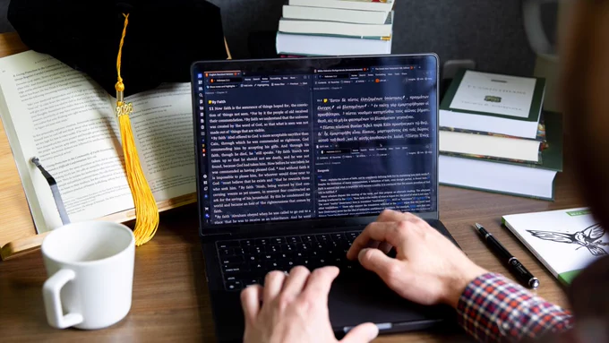 A person studies on a laptop surrounded by books. A graduation cap with '2026' tassel adds an academic theme.