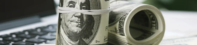 U.S. $100 currency bills on a computer keyboard