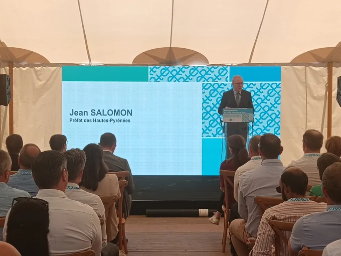 Le préfet des Hautes-Pyrénées prononce son discours derrière un pupitre et devant une assemblée.