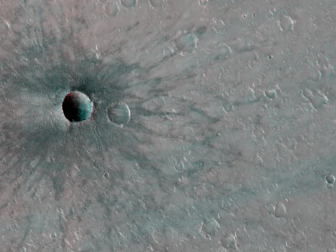 3D image shows a small impact crater on the surface of Mars. There are dark rays around the crater, called ejecta, that formed when the impact occurred, and have not faded so far.