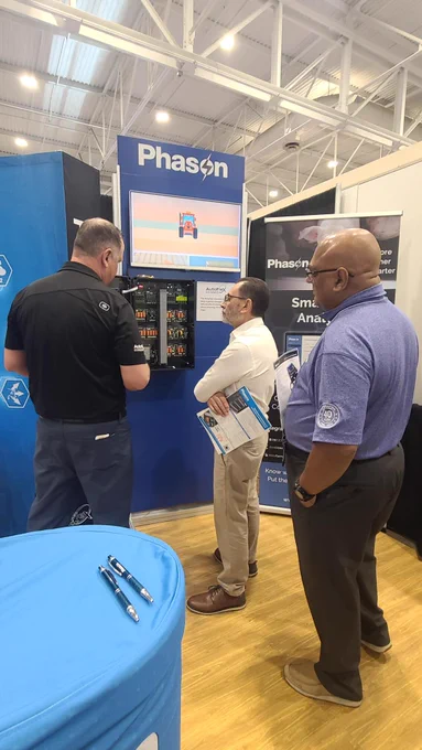 Visitors gather at the Phason Controls booth during World Pork Expo 2026 to learn about AutoFlex Connect and Smart Barn Analytics. Team members demonstrate barn automation technology.